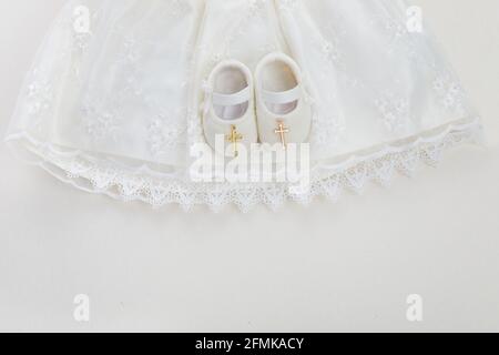 Bautizo de fondo con el bautismo de ropa de bebé, zapatos, y cruz sobre  fondo pastel Fotografía de stock - Alamy