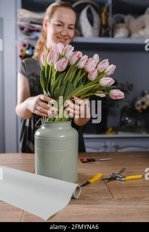 Florist girl hace un ramo de tulipanes en una flor tienda Foto de stock