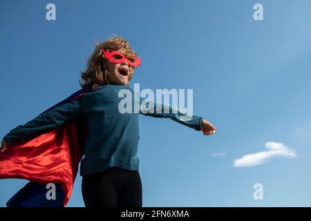 Niño con capa de superhombre. niño jugando al superhéroe. concepto ganador  de éxito y niños.