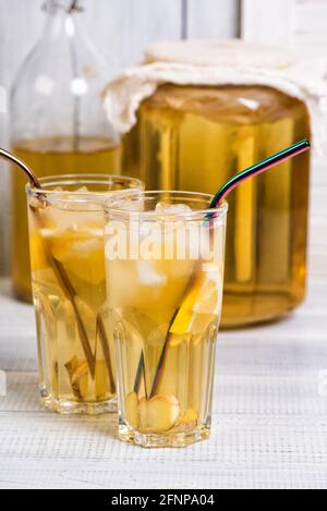 Té kombucha fermentado en casa con limón y jengibre. Vasos de limonada de verano sobre mesa de madera Foto de stock