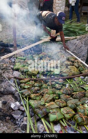 Preparación en un horno subterráneo de tamales rituales mayas para el día de los muertos: Pibipollo Foto de stock