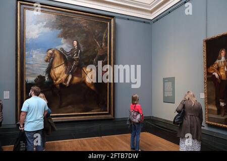 Visitantes que estudian el retrato ecuestre de Carlos I del pintor barroco flamenco Anthony van Dyck en la National Gallery, Londres, Reino Unido Foto de stock