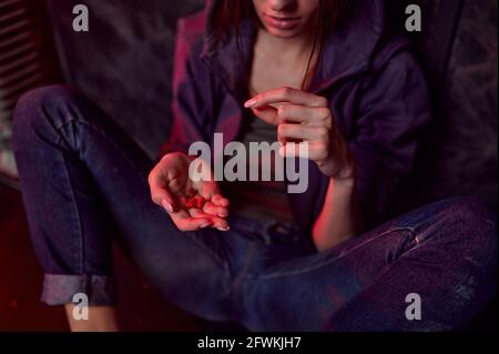 La persona femenina adicta a las drogas sostiene las píldoras, den Foto de stock