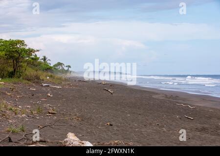 Vista de la playa negra volcánica y de las olas del océano Pacífico en Playa Hermosa en North Puntarenas, Costa Rica