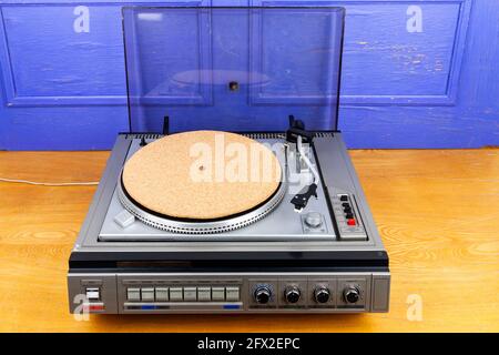 Vintage tocadiscos vinilo con vinilo rojo sobre mesa por pared azul  Fotografía de stock - Alamy