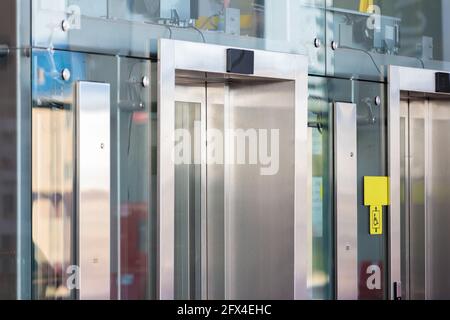 Mecanismos y detalles del ascensor de vidrio en el aeropuerto. Vista a través del cristal. Foto de stock