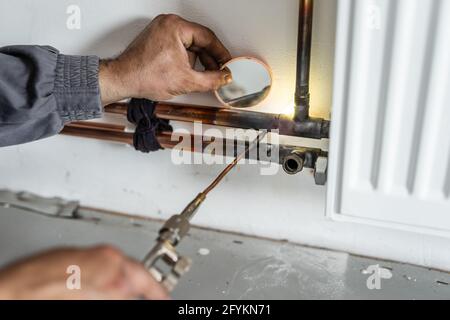 Fontanero mediante soplete de gas de soldadura para soldar tubos de cobre  de calefacción central Fotografía de stock - Alamy