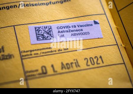 Amstetten, Austria - Mayo 30 2021: AstraZeneca Covid-19 Vaccine Sticker in a Yellow International Vacunation Certificate, A Document Cerfying Immuniza