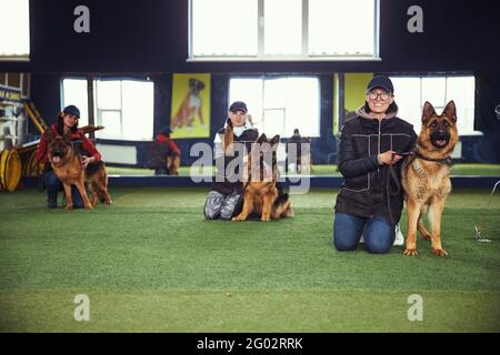 Tres mujeres y sus perros en la escuela de obediencia