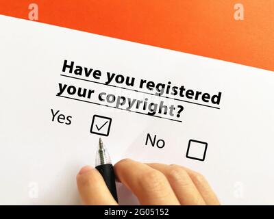 Una persona está respondiendo a la pregunta sobre el derecho de propiedad intelectual. Ha registrado sus derechos de autor. Foto de stock
