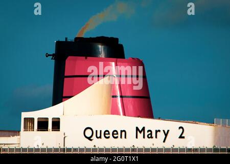 El embudo del barco crucero Queen Mary 2 brilla brillantemente bajo el sol mientras el barco está anclado en Torbay en Devon, Reino Unido. Foto de stock