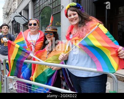 Las juerguistas cubiertas de banderas arcoiris disfrutan del desfile de Jubilee Pride en Londres, ya que 2019 marcó 50 años desde el levantamiento de Stonewall. Foto de stock