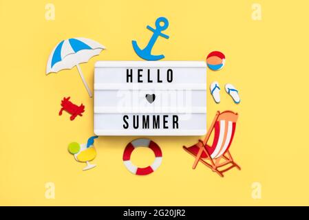 Vacaciones de verano concept.lightbox con el texto Hola verano y la playa dibujos sobre un fondo amarillo Foto de stock