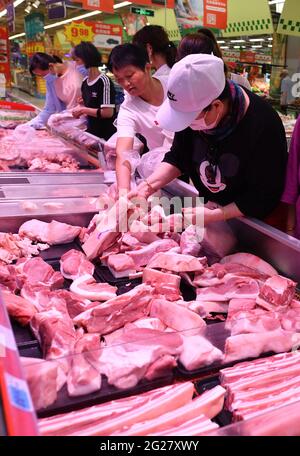 Fuyang, China. 09th de junio de 2021. Los compradores compran carne fresca en el supermercado RT Mart.El índice de precios al consumidor de China, un indicador principal de la inflación, creció un 1,3 por ciento año con año el mes pasado, frente al 0,9 por ciento registrado en abril, informó el miércoles la Oficina Nacional de Estadísticas. La lectura del IPC repuntó a medida que los precios de los alimentos subieron en medio de una oferta ajustada de pescado y huevos de agua dulce, mientras que los precios no alimentarios aumentaron con los costos de transporte elevados por los crecientes precios internacionales del petróleo crudo, indicó el NBS. Crédito: SOPA Images Limited/Alamy Live News Foto de stock