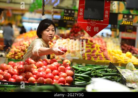 Fuyang, China. 09th de junio de 2021. Una mujer compra verduras frescas en el supermercado RT Mart.El índice de precios al consumidor de China, un indicador principal de la inflación, creció un 1,3 por ciento año con año el mes pasado, frente al 0,9 por ciento registrado en abril, informó el miércoles la Oficina Nacional de Estadísticas. La lectura del IPC repuntó a medida que los precios de los alimentos subieron en medio de una oferta ajustada de pescado y huevos de agua dulce, mientras que los precios no alimentarios aumentaron con los costos de transporte elevados por los crecientes precios internacionales del petróleo crudo, indicó el NBS. (Foto de Sheldon Cooper/SOPA Images/Sipa USA) Crédito: SIPA USA/Alamy Live News Foto de stock