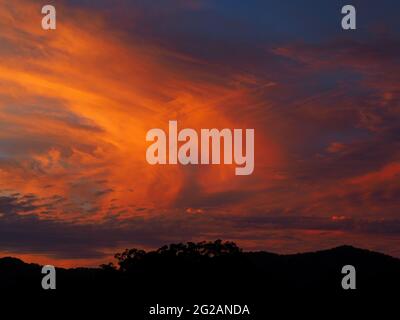 Colores vibrantes. Madre naturaleza hasta sus mejores trucos! Gloriosas y resplandecientes nubes de color naranja rosa sobre un cielo azul púrpura al atardecer, Australia