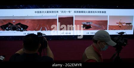 (210611) -- BEIJING, 11 de junio de 2021 (Xinhua) -- Los periodistas trabajan en la ceremonia durante la cual se desvelan nuevas imágenes tomadas por el primer rover chino de Marte Zhurong en Beijing, capital de China, 11 de junio de 2021. La Administración Nacional del Espacio de China (CNSA) publicó el viernes nuevas imágenes tomadas por el primer rover de Marte del país, Zhurong, mostrando la bandera nacional en el planeta rojo. Las imágenes fueron reveladas en una ceremonia en Beijing, lo que significa el éxito total de la primera misión de exploración de Marte de China. Las imágenes incluyen el panorama del sitio de aterrizaje, paisaje marciano y una selfie del rover con th Foto de stock