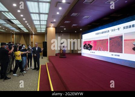 (210611) -- BEIJING, 11 de junio de 2021 (Xinhua) -- Zhang Rongqiao, diseñador jefe de la primera misión de exploración de Marte de China, presenta las nuevas imágenes tomadas por el primer rover de Marte Zhurong de China en la ceremonia durante la cual las imágenes se desvelan en Beijing, capital de China, el 11 de junio de 2021. La Administración Nacional del Espacio de China (CNSA) publicó el viernes nuevas imágenes tomadas por el primer rover de Marte del país, Zhurong, mostrando la bandera nacional en el planeta rojo. Las imágenes fueron reveladas en una ceremonia en Beijing, lo que significa el éxito total de la primera misión de exploración de Marte de China. Las imágenes inc Foto de stock