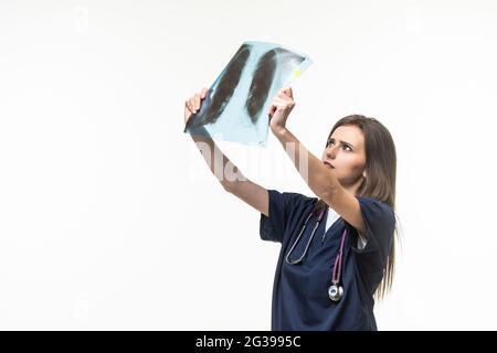 Radiografía de las costillas y los pulmones en manos de un médico. Una mujer con un estetoscopio en el cuello está estudiando fluorografía. Foto de stock