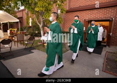Enmascarada contra la pandemia del coronavirus, una procesión de sacerdotes comienza una misa para el reconocimiento de miembros de Vida Consagrada y Jubilares en una Cali Foto de stock