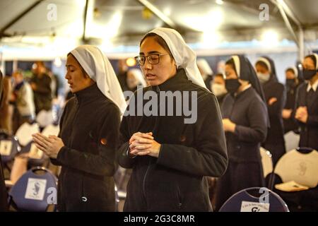 Las monjas multirraciales de costumbre oran en una misa al aire libre en una tienda de campaña para el reconocimiento de los miembros de Vida Consagrada y los jubilares en una ch católica de California Foto de stock