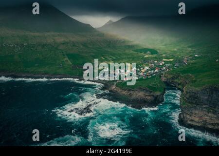 Pueblo Gjogv en Eysteroy con garganta, mar y montañas, desde arriba, Islas Feroe Foto de stock