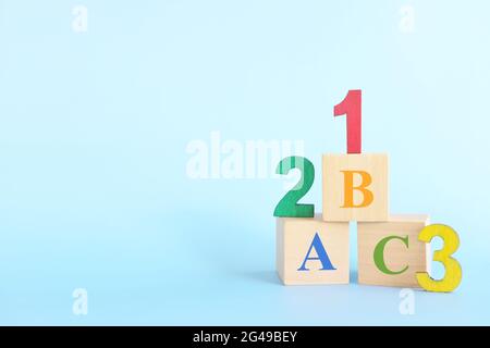 123 números coloridos y letras abc alfabeto en bloques de madera en fondo azul con espacio de copia. Principio del concepto de conteo de aprendizaje de niños o niñas. Foto de stock