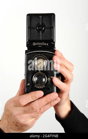 Hombre fotógrafo masculino utilizando una cámara réflex de doble lente Rolleiflex 1930s Foto de stock