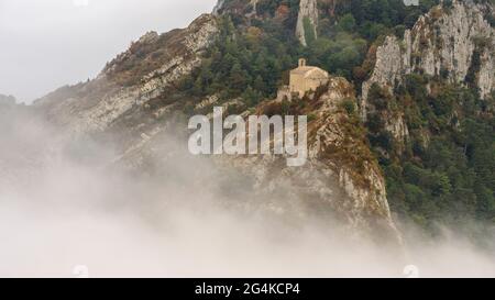 Ermita de Sant Pere de Madrona con niebla. Vista desde la cumbre de Agulles del Mercadal (Berguedà, Cataluña, España, Pirineos) Foto de stock