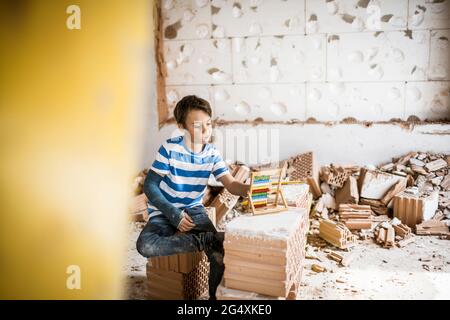 Niño contando una cuenta de abacus en la casa durante la renovación Foto de stock