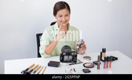 Una blogger de la belleza femenina que revisa la calidad de la paleta de colores de la vista como un nuevo producto de la llegada. Foto de stock