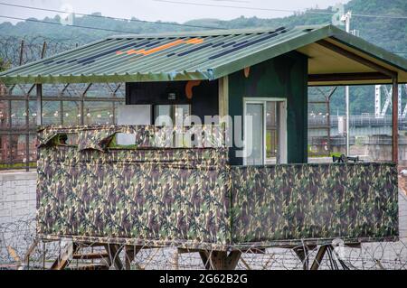 Torre de vigilancia en la zona desmilitarizada entre Corea del Norte y Corea del Sur cubierta de material verde camuflado. Foto de stock