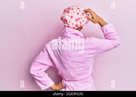 Hombre hispano con gorro de ducha y albornoz que invita a entrar sonriente  y natural con la mano abierta Fotografía de stock - Alamy