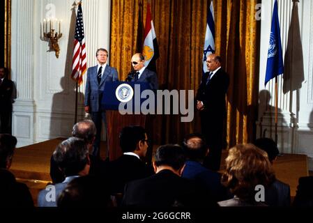 El Presidente de los Estados Unidos, Jimmy Carter, de la izquierda, escucha como Ministro de Relaciones Exteriores, Moshe Dayan, de Israel, en el centro, hace comentarios al anuncio de las conversaciones de paz entre la República Árabe de Egipto y el Estado de Israel en la Sala Este de la Casa Blanca en Washington, DC, el jueves, 12 de octubre de 1977. Las conversaciones se convocan en los Acuerdos de Camp David firmados por el Presidente Carter, el Presidente Anwar Sadat de Egipto y el Primer Ministro Menachem Begin de Israel el 17 de septiembre de 1978. A la derecha está el Ministro de Defensa General Kamel Hassan Ali de Egipto. Crédito: Benjamin E. 'Gene' Forte/CNP Foto de stock