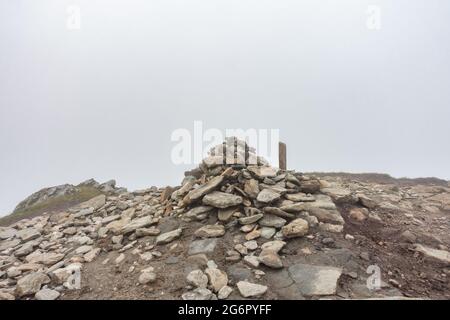 El cairn cumbre de la montaña Munro de Stob Binnein cerca de Crianlarich, Escocia, visto en un día brumoso Foto de stock