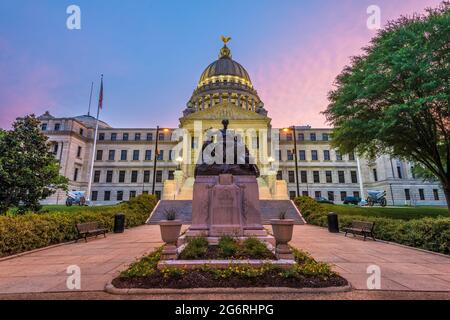 Capitolio del Estado de Mississippi en Jackson, Mississippi, Estados Unidos al atardecer con el Monumento a las Mujeres de la Confederación que data de 1917. Foto de stock