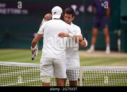 Novak Djokovic (derecha) y Matteo Berrettini después de la final de los solteros caballeros contra el día trece de Wimbledon en el All England Lawn Tennis and Croquet Club, Wimbledon. Fecha de la foto: Domingo 11 de julio de 2021. Foto de stock