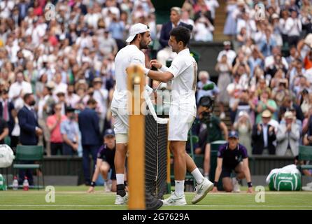 Novak Djokovic (derecha) y Matteo Berrettini después de la final de los solteros caballeros en el día trece de Wimbledon en el All England Lawn Tennis and Croquet Club, Wimbledon. Fecha de la foto: Domingo 11 de julio de 2021. Foto de stock