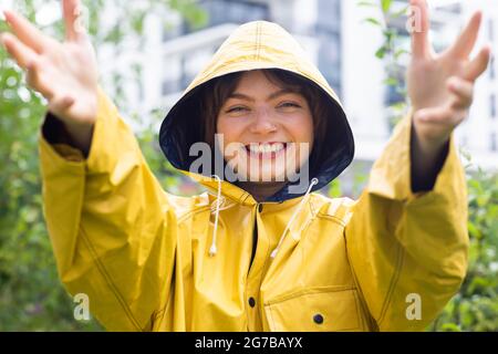 Feliz mujer joven con chubasquero amarillo con capucha, Baden