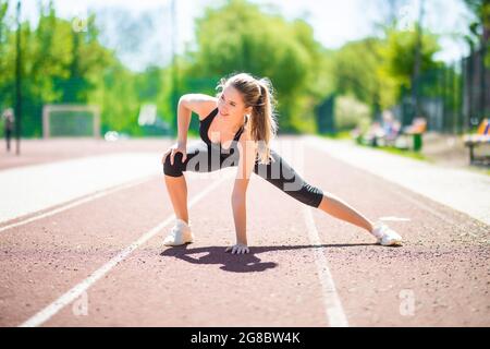 Mujer sprinter en ropa deportiva haciendo ejercicios de