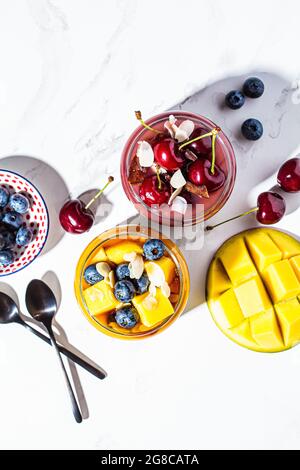 Batidos de mango y bayas en tarros, vista superior. Concepto de comida saludable, desayuno vegano. Foto de stock
