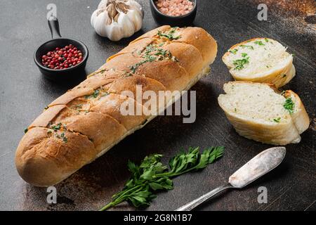Conjunto de mantequilla de hierbas compuesta rellena de pan de ajo, sobre fondo de mesa rústico oscuro antiguo Foto de stock
