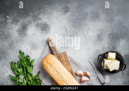 Conjunto de ingredientes compuestos de mantequilla y hierbas de pan de ajo, sobre fondo de mesa de piedra gris, capa plana de vista superior, con espacio de copia para texto Foto de stock