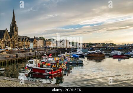 Pequeños barcos de pesca amarrados en el puerto de Newhaven al atardecer, Edimburgo, Escocia, Reino Unido Foto de stock