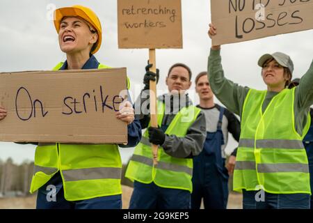Grupo de empleados en ropa de trabajo llevando carteles durante la huelga en la cantera