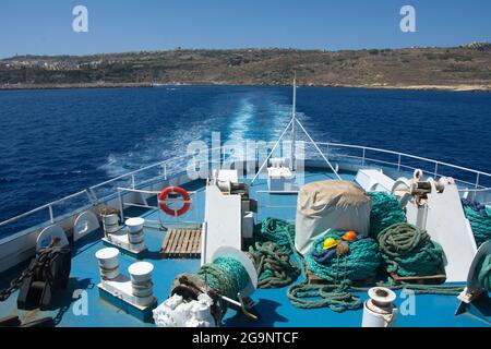 Una vista desde el ferry de pasajeros y vehículos de la Línea del Canal de Gozo que sale de la isla de Gozo. Fragmento de ferry. Cuerdas verdes y cascos de construcción