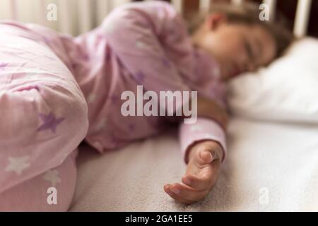 Lindo alegre niño pequeño de 3-4 años preescolar niña durmiendo dulcemente  en cuna blanca durante el almuerzo tiempo de descanso en pijama rosa con  almohada en casa Fotografía de stock - Alamy