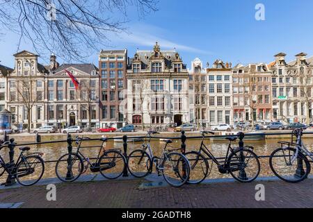 Bicicletas estacionadas en Herengracht, frente a edificios de dos aguas, incluyendo Grachtenmuseum, Amsterdam, Holanda Foto de stock