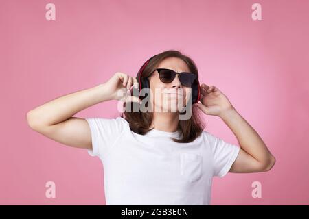 el hombre con gafas de sol escucha música con auriculares y bailes Foto de stock