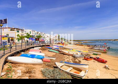 Barcos de pesca tirados en la playa frente al paseo marítimo en Cabanas Algarve Este Portugal Foto de stock